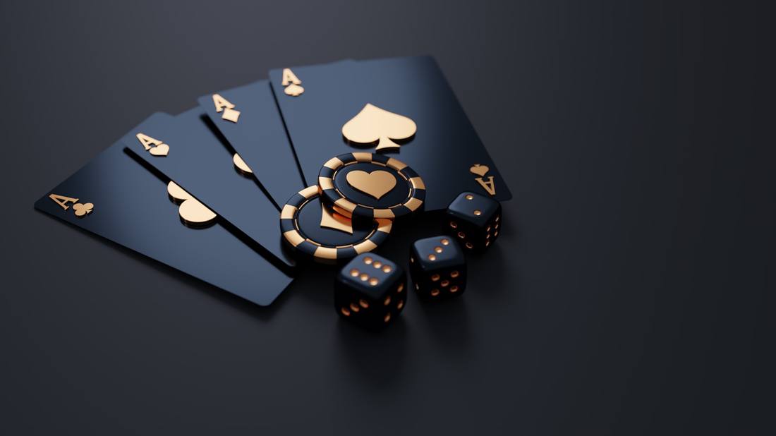 Black playing cards with gold aces, poker chips, and dice on dark surface