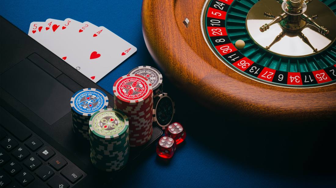 Roulette, kartu remi, dan chip di atas meja kasino