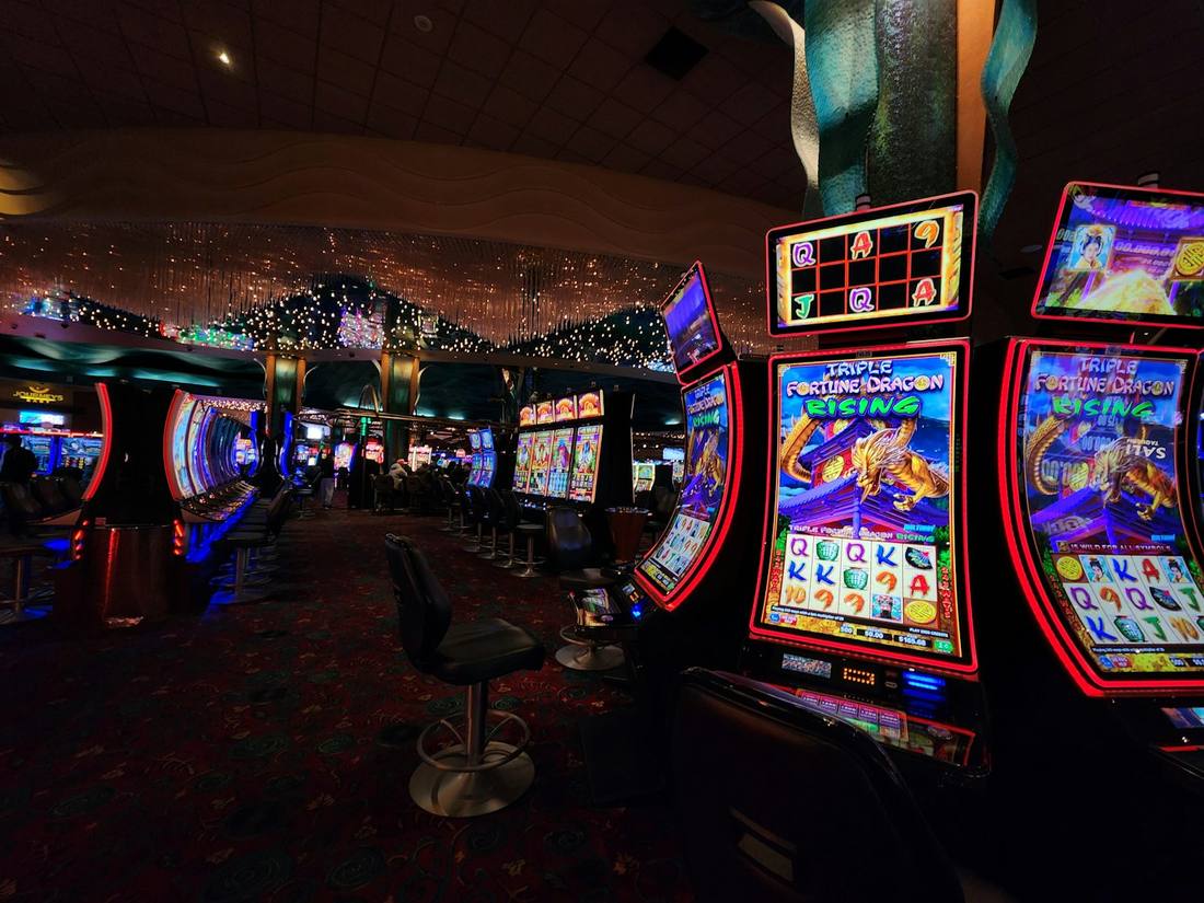 Ruang kasino dengan deretan mesin slot menyala