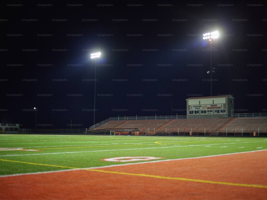 Lapangan sepak bola di bawah lampu stadion malam hari